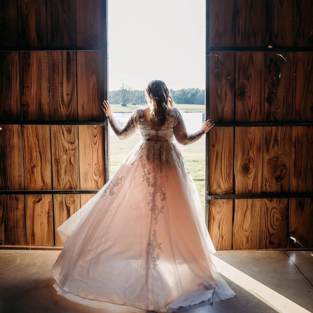 bride standing near barn doors